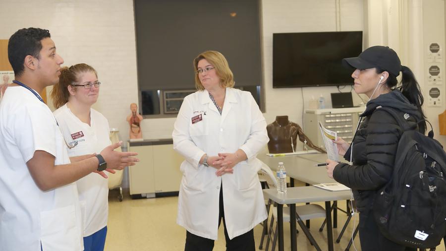 medical interpreting student in scrubs practicing with patient